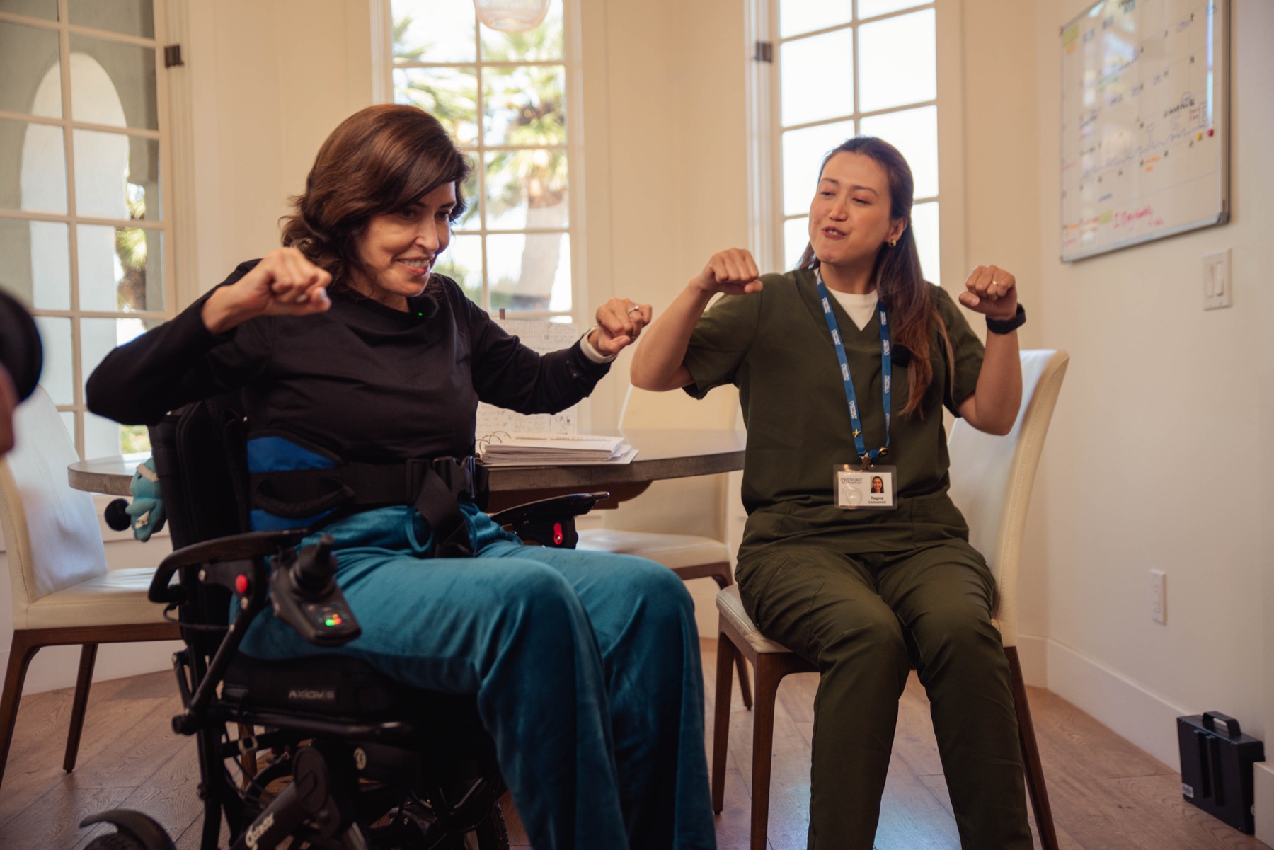 A caregiver and client doing a playful exercise routine together