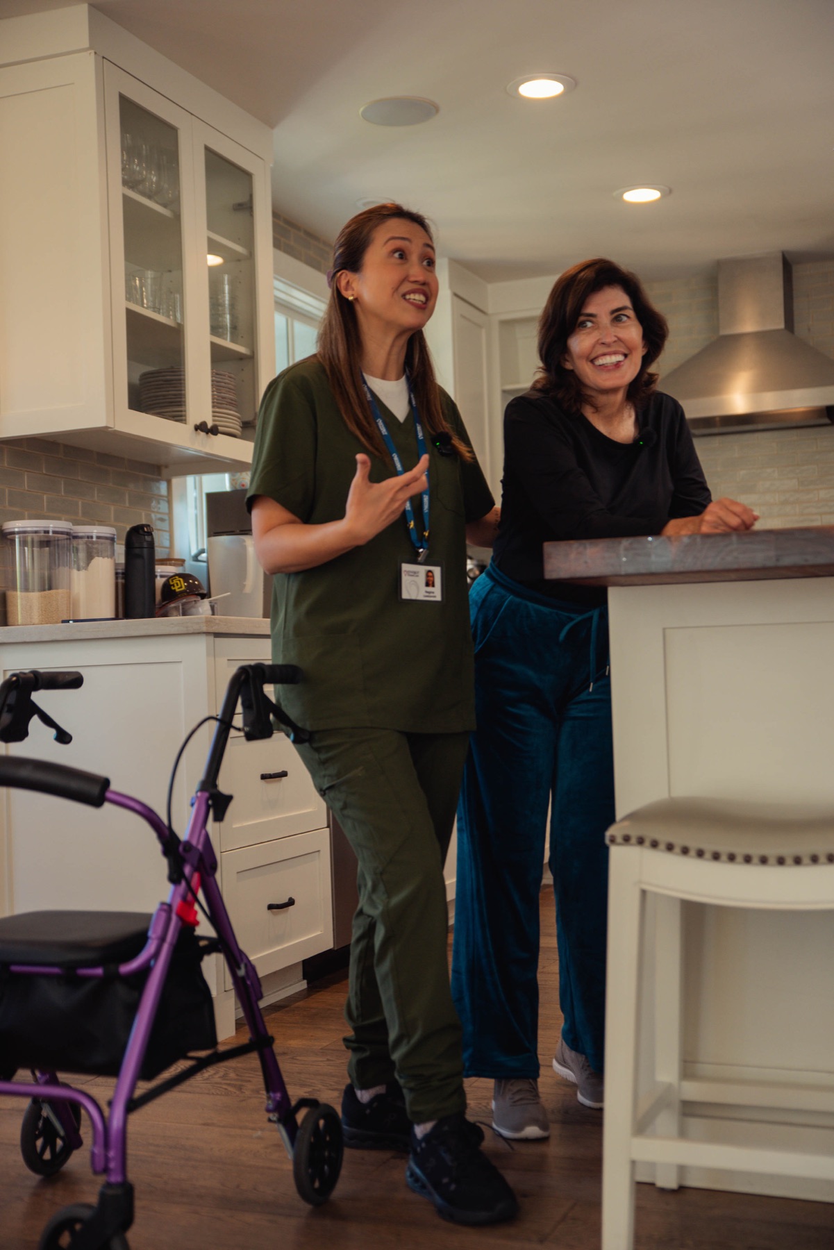 A caregiver and client sharing a story in the kitchen