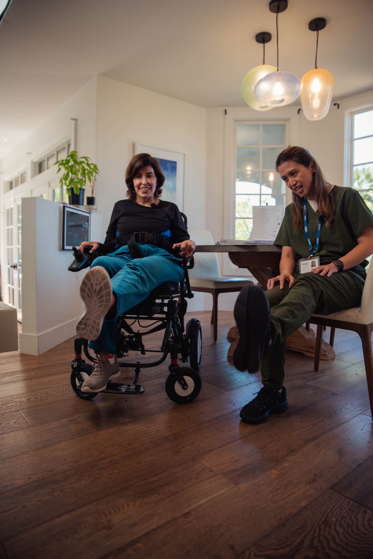 A caregiver and client sharing a playful, joyful moment at home