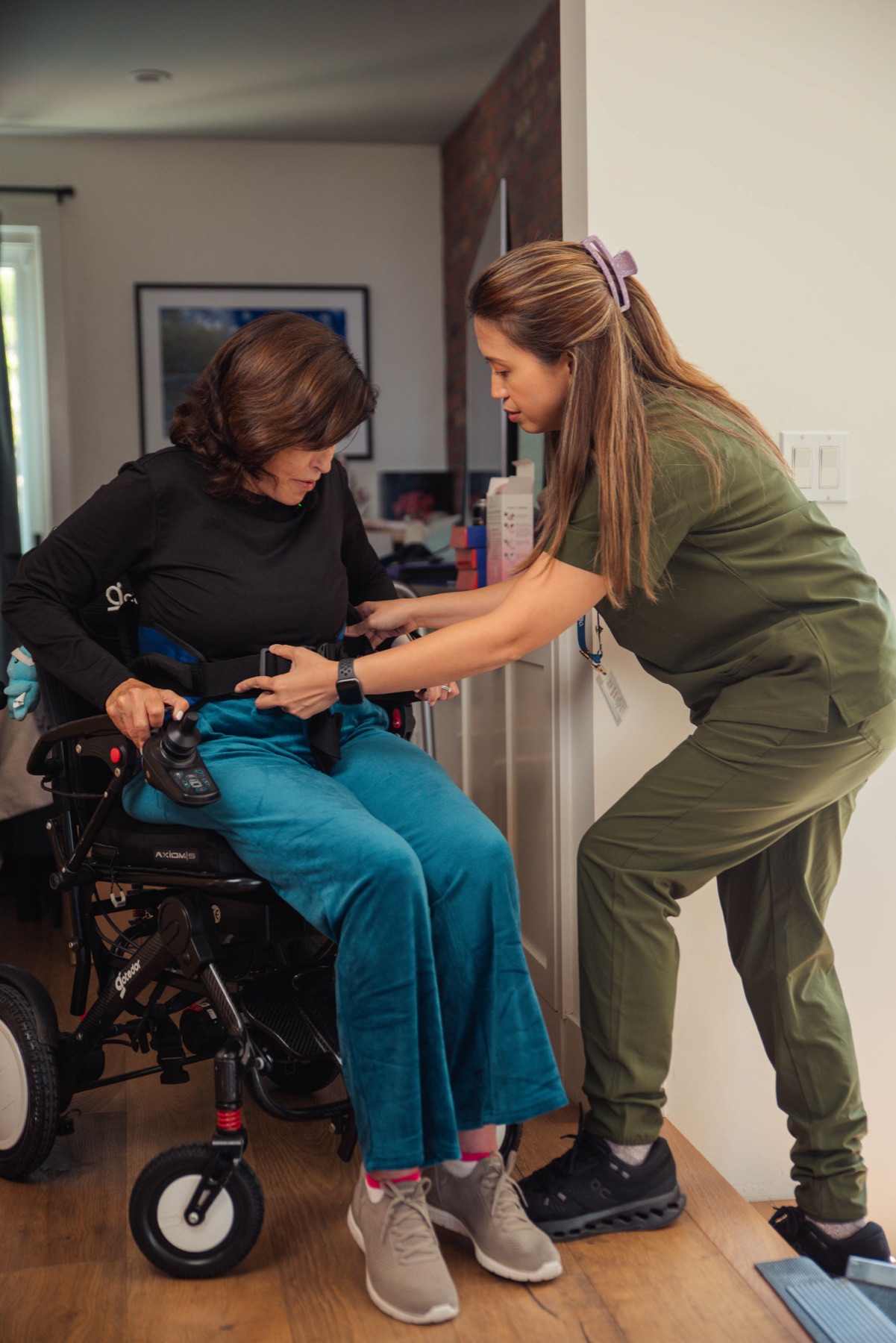 A caregiver steadying a client using a rollator near a staircase
