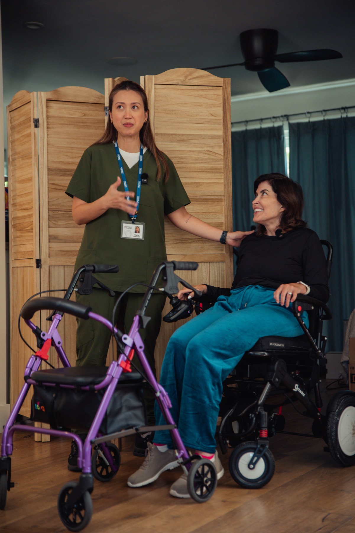 A caregiver checking in with a client in her wheelchair
