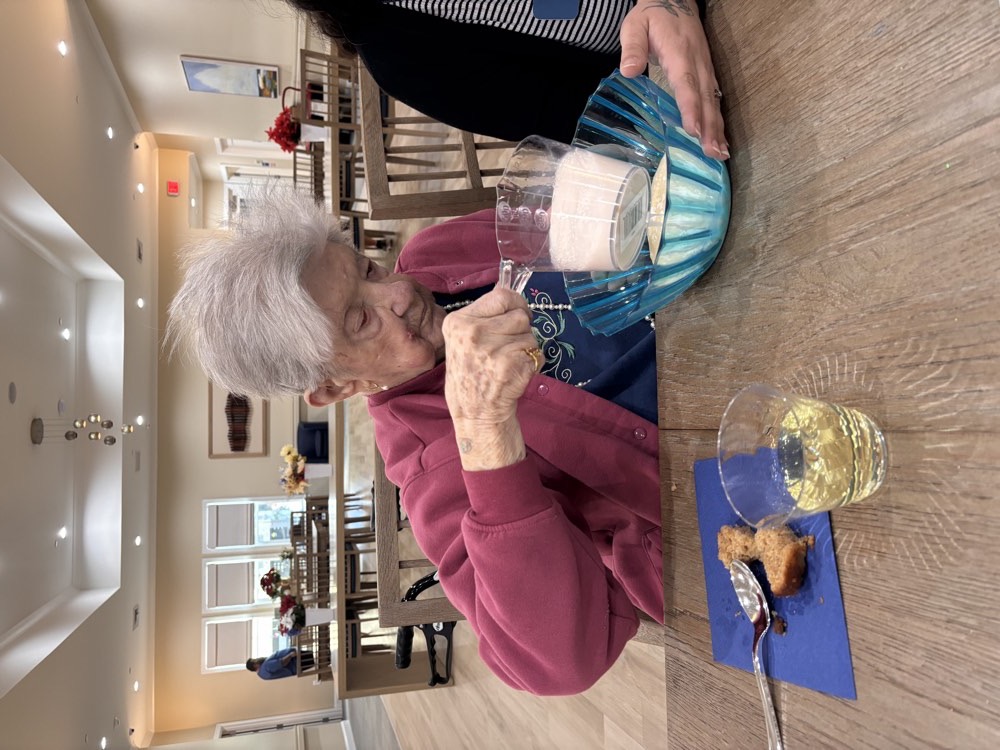 A caregiver serving a client at the dining table
