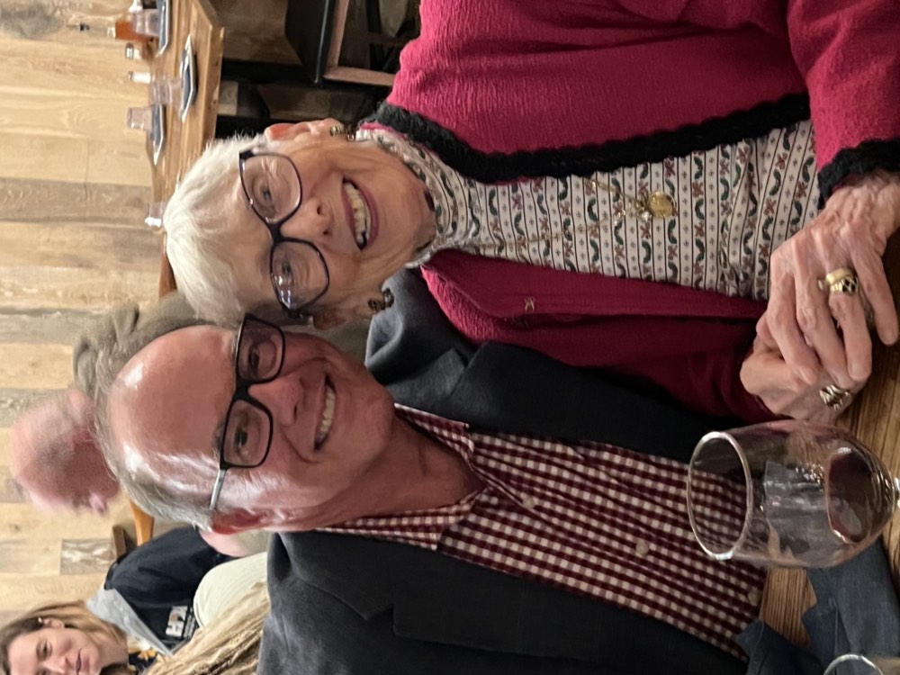Two members of the SYNERGY HomeCare of North County team laughing together at dinner