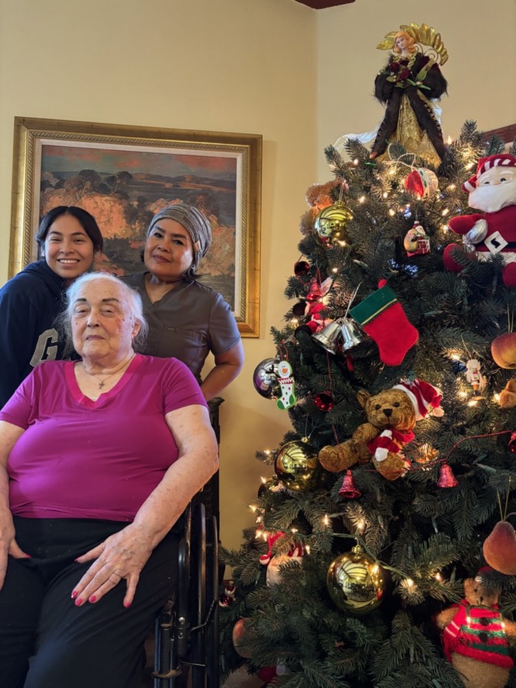Two caregivers with their client, decorating for the holidays